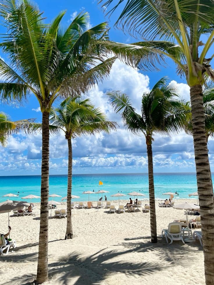 Playa de Cancún con palmeras y aguas turquesas del Caribe mexicano — paquete todo incluido desde Chile